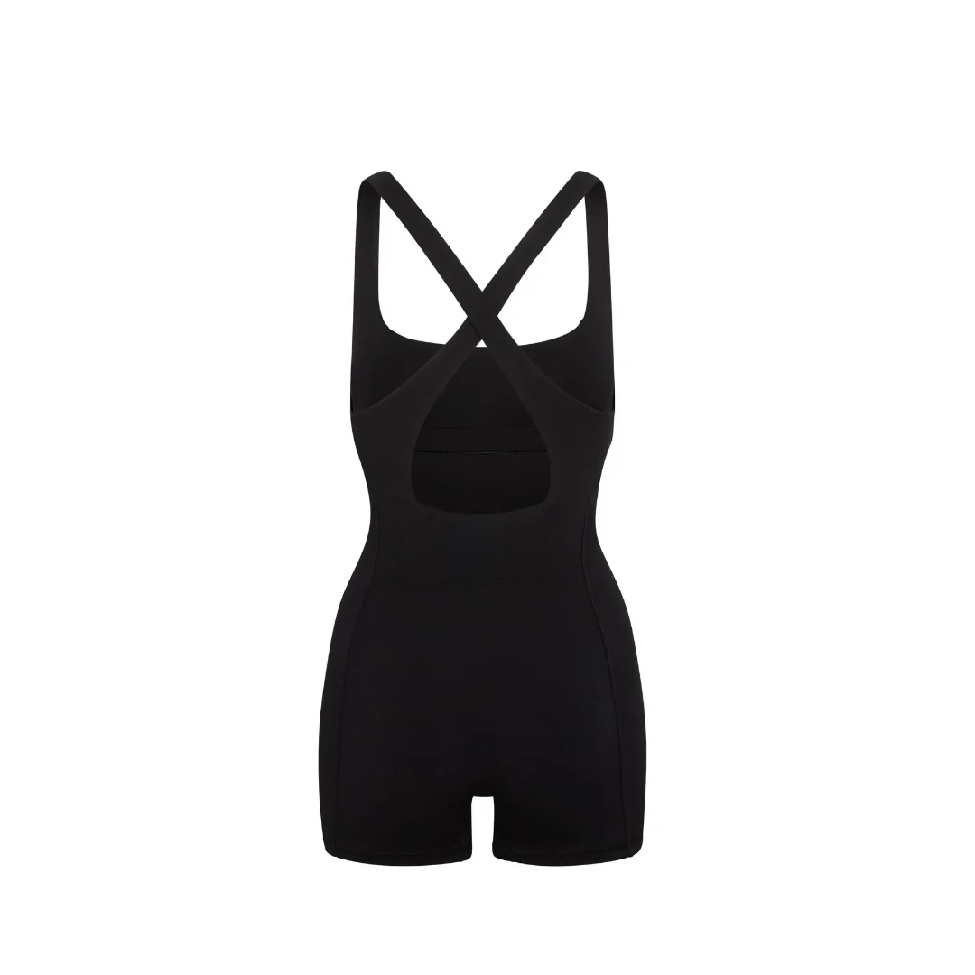 Freigestellter Core Calm Shorty Overall in Schwarz, Rückansicht mit überkreuzten Trägern auf weißem Hintergrund.