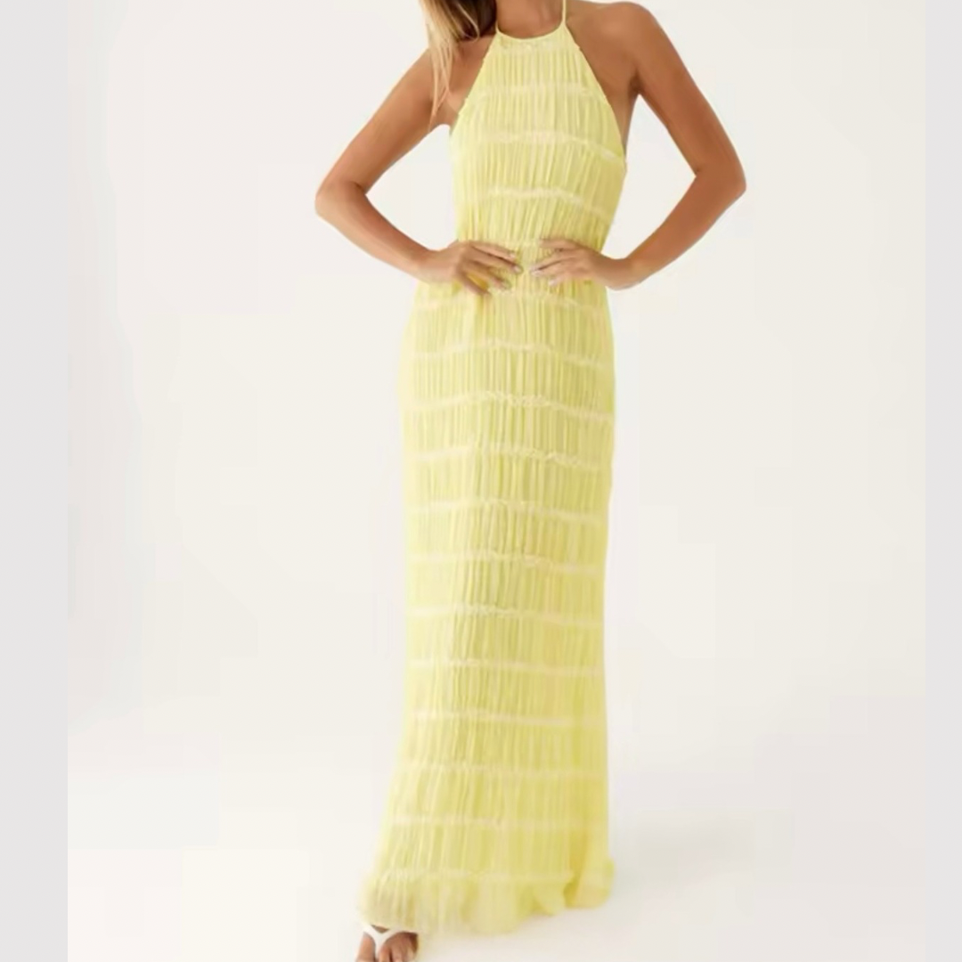 Model trägt strukturiertes Halterneck-Sommerkleid in Vorderansicht – figurbetontes Design in Gelb.